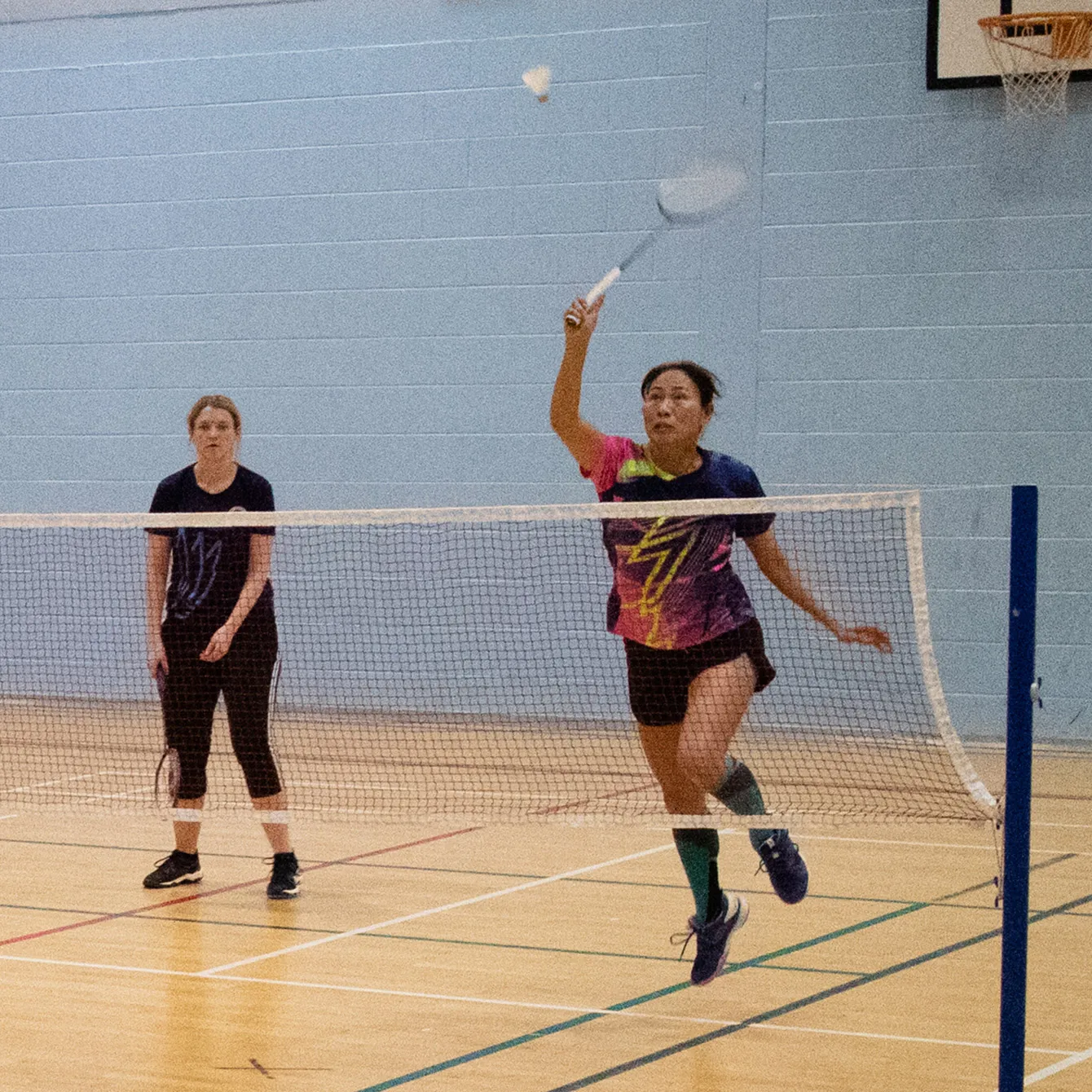 A lady from Broadlands Badminton Club jumping up to smash the shuttle